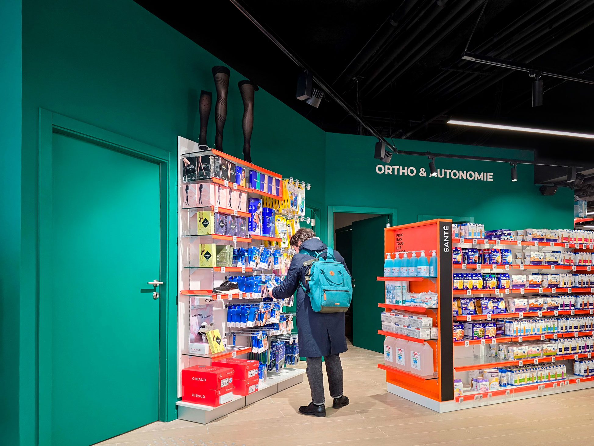 Pharmacie Colombia Lafayette – Medd Agencement Client parcourant les linéaires modernes et bien organisés de la Pharmacie Colombia Lafayette, espace conçu par Medd Agencement.