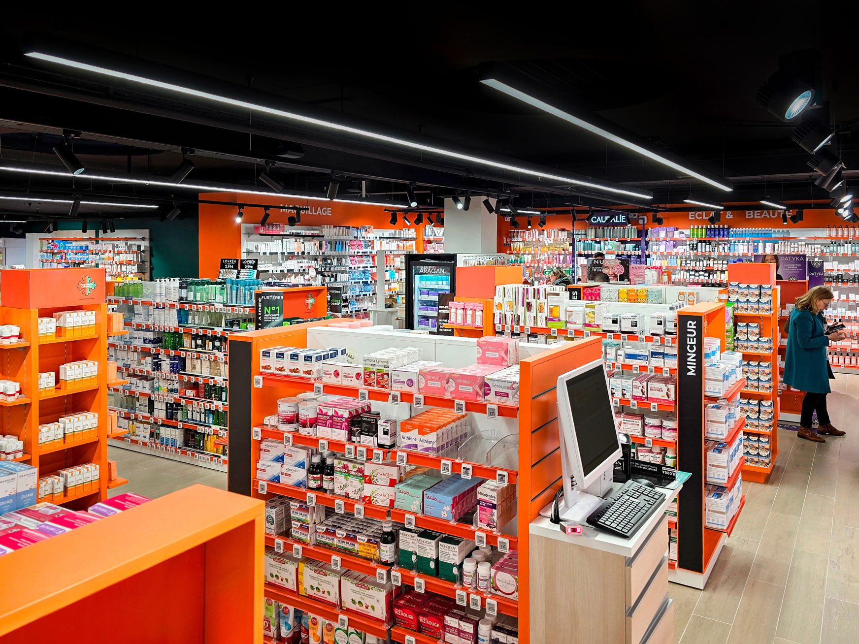 Pharmacie Colombia Lafayette – Medd Agencement Présentoirs en bois clair sur mesure dans la Pharmacie Colombia Lafayette, favorisant la lisibilité des produits et la fluidité du parcours client, conçus par Medd Agencement.
